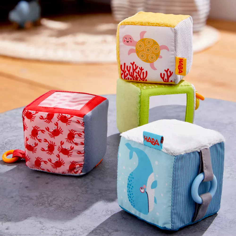 Textilné kocky pre bábätká s aktivitami 4 ks Haba